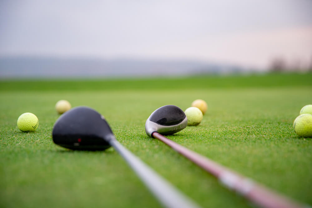 golf balls and sticks on green golf course