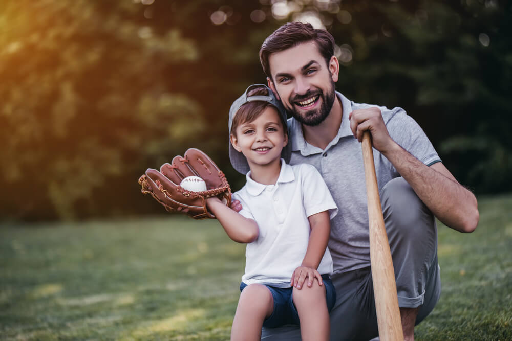 Handsome Dad With His Son Playing Baseball on Green Grassy Lawn