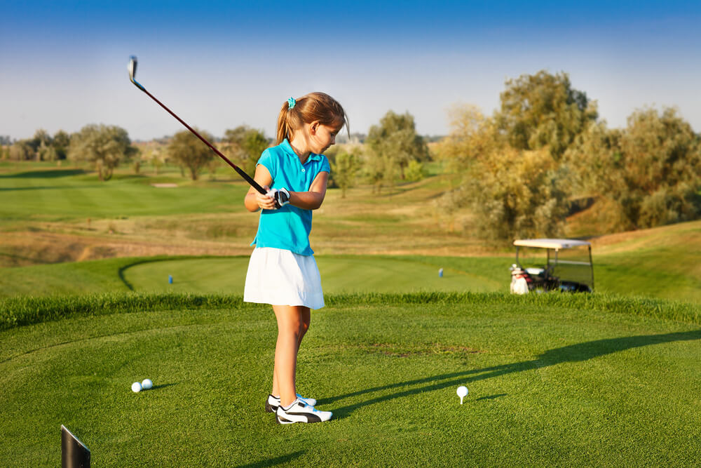 Cute Little Girl Playing Golf on a Field Outdoor. Summertime